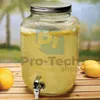 A glass beverage dispenser filled with lemonade and lemon slices, placed on a wooden surface outdoors. Náhľad obrázku produktu