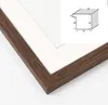 A close-up view of a brown wooden picture frame with a white mat, showing a diagram of the frame's dimensions in the upper right corner. Anteprima dell’immagine prodotto