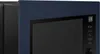 A close-up view of a dark blue and black microwave oven. Voir les images du produit