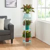 A plant stand with three tiers of plants next to a sofa and a window. Náhled obrázku produktu