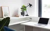 A modern white desk with a laptop, a plant, and a framed picture. Produktbild-Vorschau