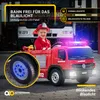 A child dressed as a firefighter is sitting in a red toy fire truck with flashing blue lights. Produktbild-Vorschau