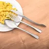 A place setting with a plate of potato salad and cutlery on a wooden table. Produktbild-Vorschau