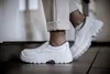 A person wearing white work pants and white slip-on shoes. Produktbild-Vorschau