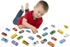 A young boy is lying on the floor playing with a collection of toy cars. Podgląd zdjęcia produktu