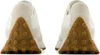 The back view of two beige New Balance sneakers with brown rubber soles. Anteprima dell’immagine prodotto