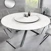 A modern dining room setting with a round dining table and chairs. Produktbild-Vorschau