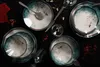 A dark, moody table setting with multiple plates, bowls, cutlery, and glasses, decorated with small red berries and nuts. Voir les images du produit