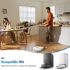A family is having dinner in a kitchen, and a robot vacuum is cleaning the floor. Produktbild-Vorschau