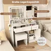A white vanity table with a mirror, drawers, and cabinets, set up in a bedroom next to a bed. Voir les images du produit