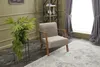 A chair in a living room setting with plants and a bookshelf. Produktbild-Vorschau