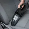 A hand holding a black handheld vacuum cleaner to clean a car seat. Produktbild-Vorschau