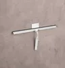 A shower squeegee is mounted on a wall with a hook. Produktbild-Vorschau
