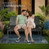 A couple sitting on a garden bench in front of a house. Náhled obrázku produktu