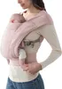 A woman is wearing a baby carrier with a baby inside. Produktbild-Vorschau