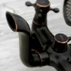 A close-up shot of a black and bronze bathtub faucet. Anteprima dell’immagine prodotto