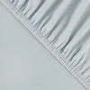 A close-up view of a light blue fitted sheet with elastic gathering along the edge. Produktbild-Vorschau