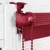 Close-up of a red roller blind mechanism attached to a white window frame. Produktbild-Vorschau
