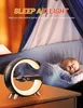 A baby sleeping in a crib next to a sleep aid light on a nightstand. Produktbild-Vorschau