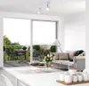 A modern living room with a balcony view, featuring a sofa, coffee table, and a dining set on the balcony. Produktbild-Vorschau