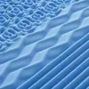 A close-up, abstract view of a blue foam mattress with different textured zones. Produktbild-Vorschau
