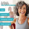 A smiling older woman in athletic wear is shown in the foreground, with blurred figures exercising in the background. Text overlays describe different fitness activities. Produktbild-Vorschau