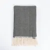 A folded gray herringbone blanket with cream fringe is laid flat on a white background. Anteprima dell’immagine prodotto