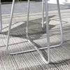 Close-up of the legs of a light gray bistro set on a patterned outdoor rug. Náhled obrázku produktu