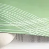 A close-up of a green fabric with a white water wave pattern, partially covering a book with text. Produktbild-Vorschau