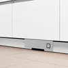 A close-up view of the bottom section of a modern kitchen appliance, likely a dishwasher or oven, with a built-in vacuum system. Podgląd zdjęcia produktu
