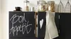 A kitchen scene with black cabinets, one of which has chalk writing on it. Produktbild-Vorschau