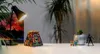 A desk with a lamp, a puzzle box, a plant, a Rubik's cube, and a figurine. Náhľad obrázku produktu