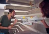 Two people are interacting with a model of the Starship Enterprise hanging from the ceiling. Podgląd zdjęcia produktu