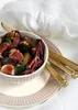 A close-up of a salad with figs, plums, blackberries, walnuts, and radicchio, served in a bowl on a decorative plate with gold cutlery. Produktbild-Vorschau