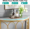 A close-up view of a white faux marble console table with a gold metal frame, decorated with bottles, glasses, and a vase of white tulips. Podgląd zdjęcia produktu