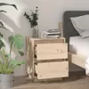 A wooden nightstand with two drawers next to a bed, with a plant and some books on top. Produktbild-Vorschau