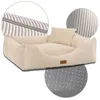 A cream-colored dog bed with a pillow, shown with close-up details of the fabric texture and the non-slip bottom. Produktbild-Vorschau