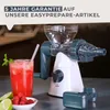 A manual juicer with a glass of juice, limes, and raspberries. Produktbild-Vorschau