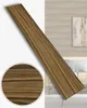 A wooden plank with a close-up inset, set against a blurred background of a room with wood-paneled walls and furniture. Produktbild-Vorschau