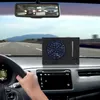 A hand on the steering wheel of a car, with a portable fan on the dashboard. Podgląd zdjęcia produktu