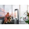 A family relaxing in a living room with a tower fan. Podgląd zdjęcia produktu