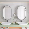 A modern bathroom vanity with two oval mirrors, sinks, and faucets. Anteprima dell’immagine prodotto