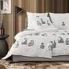 A bed with penguin-themed bedding in a room with wooden walls. Produktbild-Vorschau