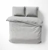 A neatly made bed with a duvet and two pillows, all in a light gray striped pattern. Anteprima dell’immagine prodotto