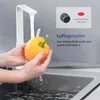 A person is washing a yellow bell pepper under a white kitchen faucet. A close-up of a faucet aerator is shown in a small box. Podgląd zdjęcia produktu