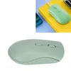 A light green wireless mouse is shown against a white background. A smaller inset image shows the same mouse connected to a charging cable, placed on a yellow book next to a smartphone. Náhled obrázku produktu