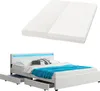A white bed frame with a mattress and blue bedding, shown from a diagonal angle. The bed has LED lighting in the headboard and drawers underneath. Produktbild-Vorschau