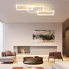 A modern living room with a fireplace, sofa, coffee table, and abstract art on the wall, illuminated by a ceiling light. Produktbild-Vorschau