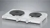 A white electric double hot plate with two black heating elements and two control knobs sits on a metallic surface against a gradient gray background. Produktbild-Vorschau