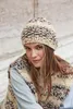 A woman wearing a knitted hat and vest. Produktbild-Vorschau